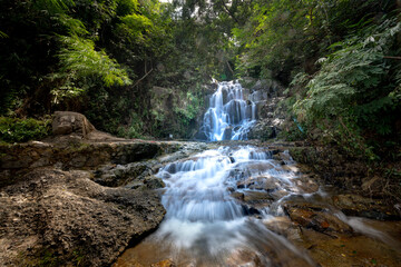 Fototapeta na wymiar Stream flowing through rock crevices in the rainforest