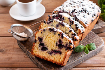 Home baked cake with blueberries on wooden table