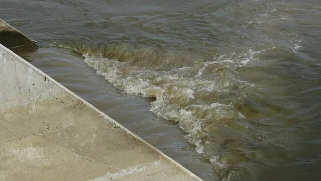 Sewage pipe outfall into the river, water pollution and environmental damage concept in slow motion