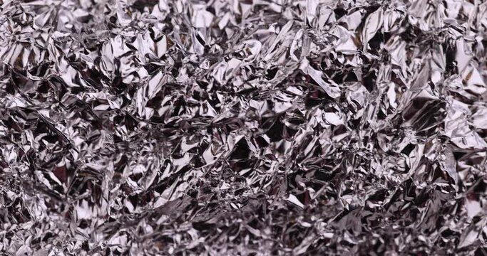 move old used crumpled aluminum foil, close-up of a foil structure with crumbs from food