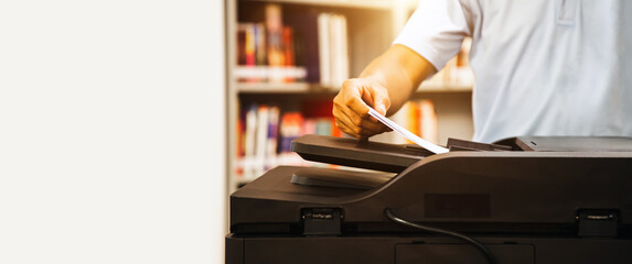 Photocopier printer, close up hand office man using the copier or photocopy machine for scanning document or printing paper or Xerox a sheet. - obrazy, fototapety, plakaty