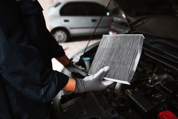 Car air conditioner system maintenance, Hand mechanic holding car air filter to check for clean...