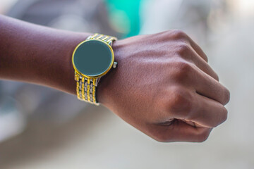 A gold color watch in the hand of a boy