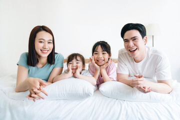 Young Asian family on bed