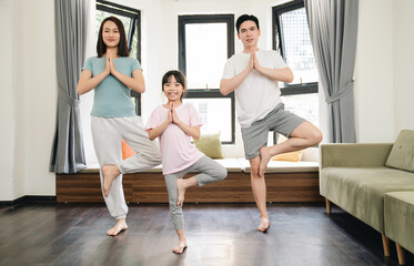 Fototapeta na wymiar Young Asian family exercise at home
