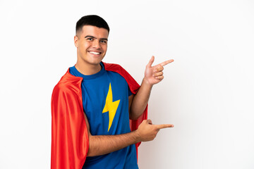 Super Hero over isolated white background pointing finger to the side and presenting a product