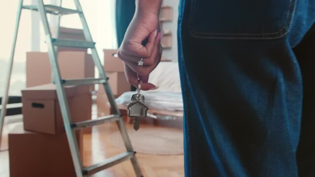 Landlord woman hand with keys to front door entering new house for first time with many boxes of things after renting property in steep area of city and contacting real estate agency