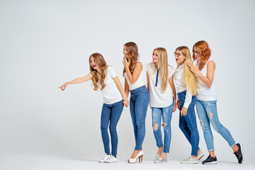 Your tex here. Group of amazed young women looking away and pointing copy space on white background.