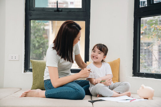 Image of young Asian mother and daughter at home