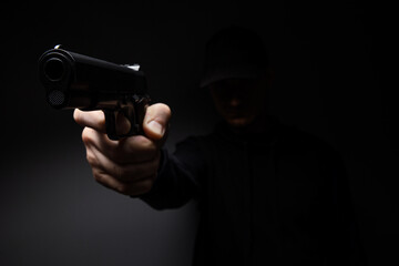 Close up of man hand with aiming gun on a black background.