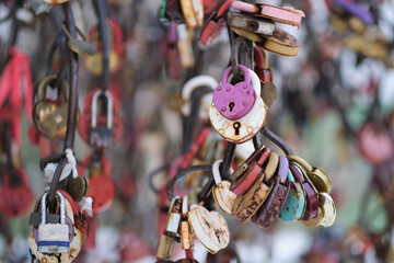 close up old rusty locks heart shaped on wire rope. Love lock on the bridge. tradition of hanging a barn lock on the wedding day