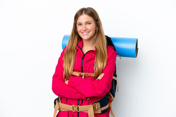 Young mountaineer girl with a big backpack over isolated white background keeping the arms crossed...