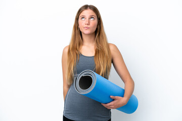 Young sport woman going to yoga classes while holding a mat and looking up