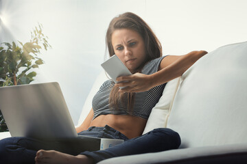Woman on couch, laptop and phone interrupted - obrazy, fototapety, plakaty