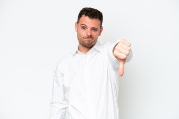 Young caucasian handsome man isolated on white background showing thumb down with negative...