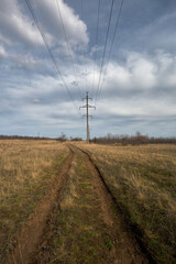 The road stretches into the distance. Power line next to the road going into the distance