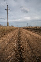 The road stretches into the distance. Power line next to the road going into the distance