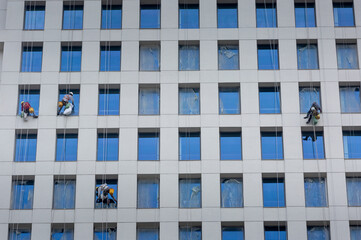 Ho Chi Minh City, Vietnam - workers are cleaning the glass of an office building. This is a dangerous profession