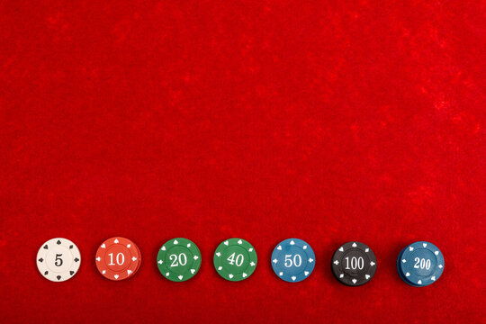 Gaming Chips on Red Velvet Playing Table - Casino and Gambling Concept for Poker and Table Games