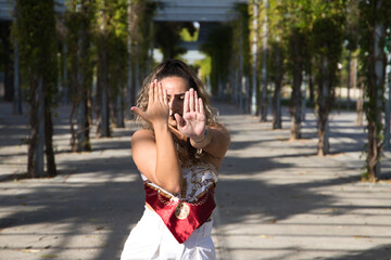 Latin woman, young and beautiful dancing modern dance in the street in a park and makes different expressions and postures. Concept dance, hip hop, dance, art, action, beauty, youth art.