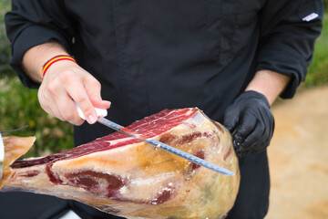 Detail of an Iberian ham cut by a professional. Concept pork, food, ham, iberian, spain, denomination of origin. - obrazy, fototapety, plakaty