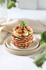 Pancakes with strawberry and fruits on a white background.