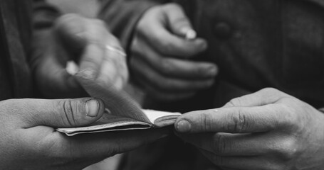 Close up detail german soldiers World War II s uniform. German military decoration on the uniform. Soldiers holding checking in their hands and flip through paper documents id passport. Black And