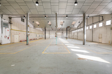 Empty spacious hall with metal beams and lamps prepared for a parking lot or factory. Concept...