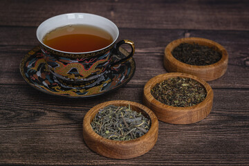 Obraz na płótnie Canvas tea leaves on a rustic background. black tea, milk oolong, tea blend. Tea in wooden bowls
