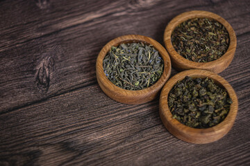 tea leaves on a rustic background. black tea, milk oolong, tea blend. Tea in wooden bowls