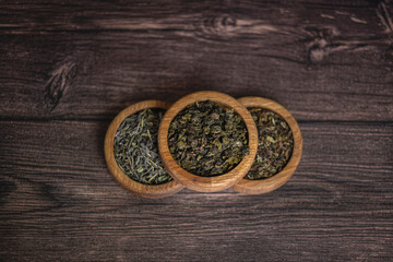 tea leaves on a rustic background. black tea, milk oolong, tea blend. Tea in wooden bowls