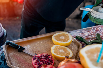 a man cutting a pomelo fruit on a board and making juice at the market, bazaar