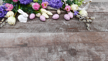 Obraz na płótnie Canvas Ostereier mit Blumen Arrangement bestehend aus Tulpen und Hyazinthen auf Holzhintergrund mit Platz für Text.