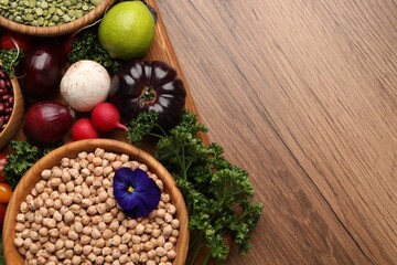 Different vegetables on wooden table, flat lay and space for text. Vegan diet
