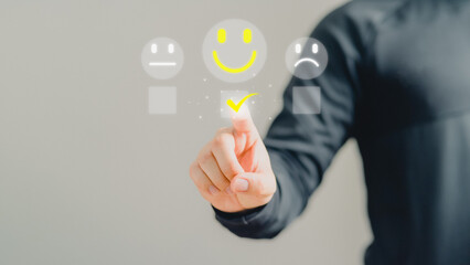 Business man are touching the virtual screen on the happy smile face icon to give satisfaction in service. Opinion rating very impressed. Assessment testimonial customer service and feedback concept.