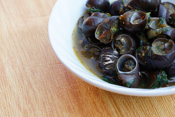 Kaeng Hoi Khom, River snails or Periwinkle curry on white bowl. Concept : Edible snails that can be cooked in various delicious menu. Weird food. Thai taditional local food.                           