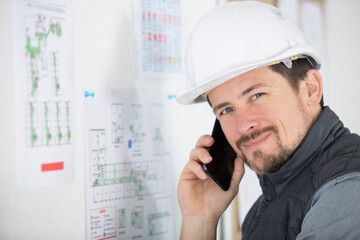 professional construction worker checking a project and calling