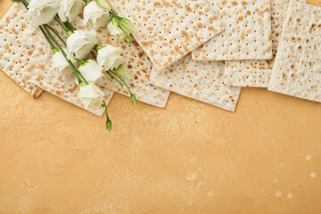 Passover Pesah celebration concept. Matzah, kosher red wine, walnut and white and yellow roses. Traditional ritual Jewish bread on sand color old tile wall background.  Pesach Jewish holiday. Top view