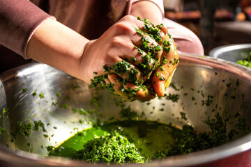 Hand squeezing chopped spinach leaves