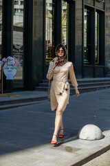 A girl in glasses walks around the city