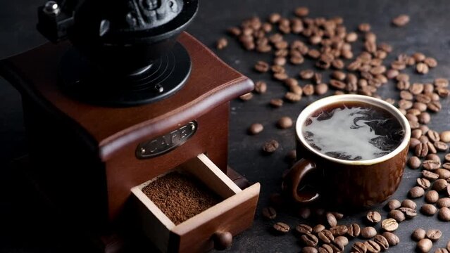 Woman grinds coffee on a manual coffee grinder, slow motion, dark background