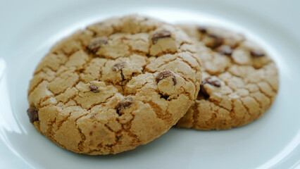 Cookies with pieces of chocolate on a white plate