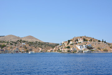 Fototapeta na wymiar A view of the greek island Symi with boats and buildings from the water 