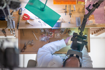 Downward view of a clock workshop. Clockmaker repairing wrist watch
