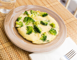 wholesome breakfast. omelet with broccoli on brown plate