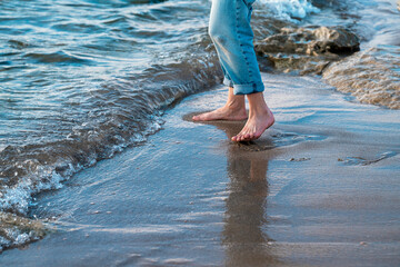 Close up of woman feet walking barefoot on seaside . Vacation, travel and freedom concept. People relaxing in summer.