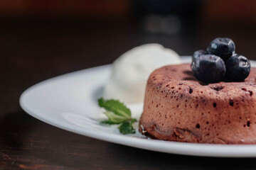 petit g?teau, chocolate fondant, dessert composed of a small chocolate cake with crunchy rind and mellow filling that is served hot with vanilla ice cream on a plate.