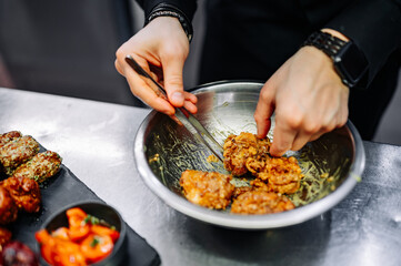 chef cooking chicken wings in a sauce in the kitchen