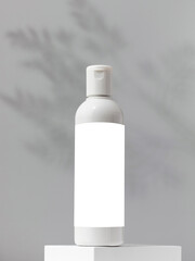 Empty bottle with a cosmetic product with a place for a logo on a pedestal. Micellar water, facial cleansing lotion.