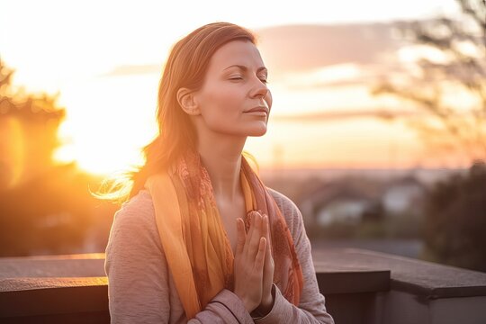 Woman meditating and relaxing outside at sunset
